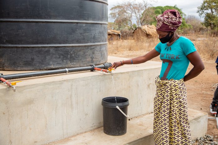 woman-standing-next-to-a-water-tank